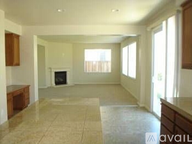 A spacious living room with a fireplace and large windows.
