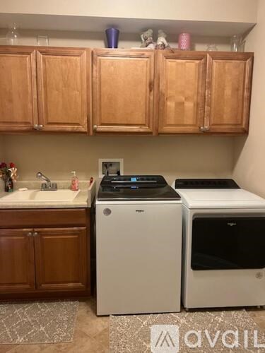 A kitchen with wooden cabinets and a white dishwasher and dryer.