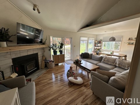 A living room with a fireplace and a television on the wall.