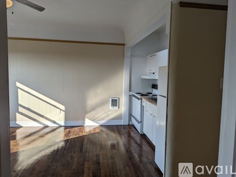 A kitchen with white cabinets and a wooden floor.