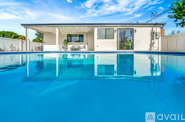 A modern house with a pool in front.