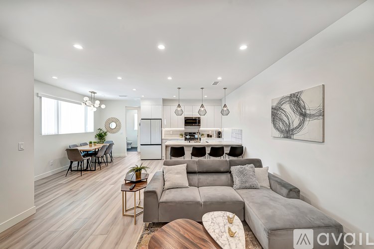 A modern living room with a grey sofa and a dining table.