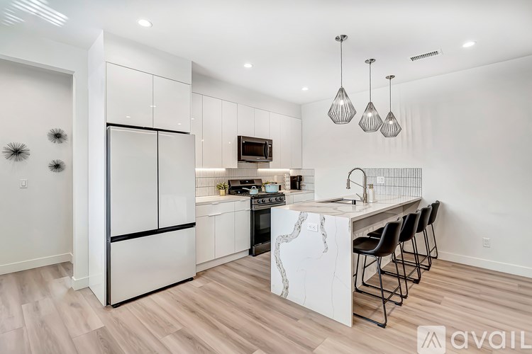 A modern kitchen with a marble island and stainless steel appliances.