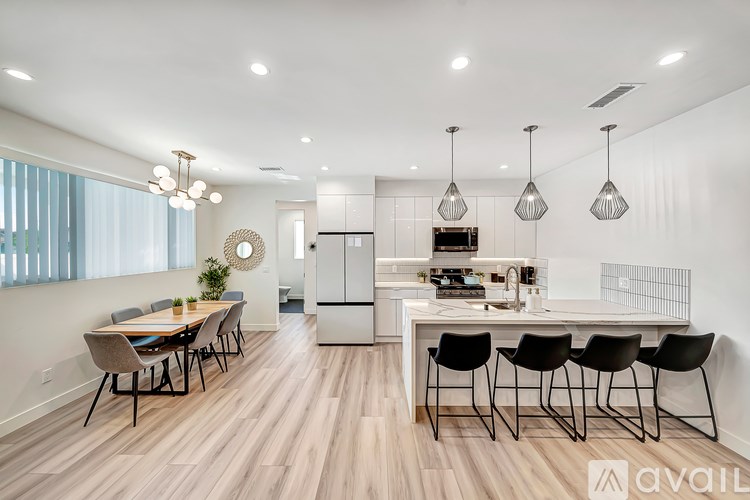 A modern kitchen with a dining table and chairs.