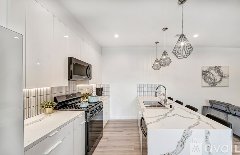 A modern kitchen with a marble island and stainless steel appliances.