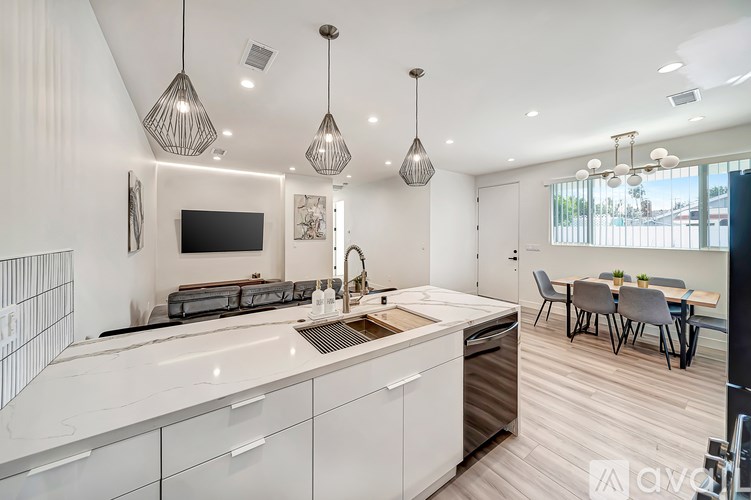 A modern kitchen with white cabinets and a wooden countertop.