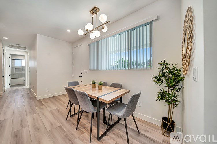A dining room with a wooden table and chairs.