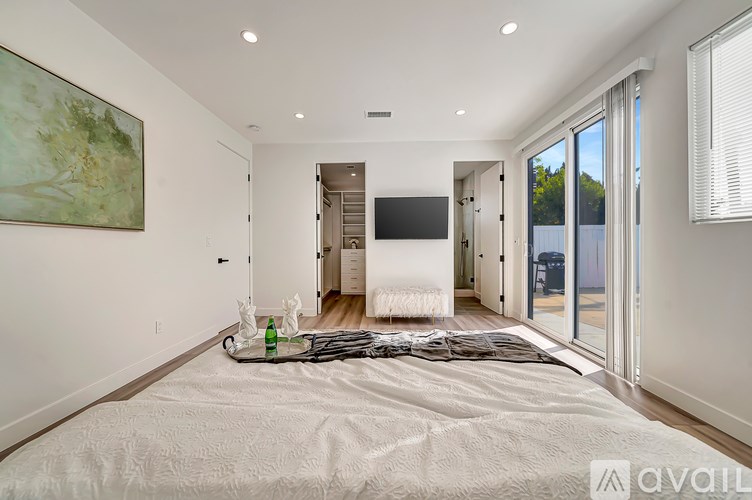 A bedroom with a large bed and a painting on the wall.