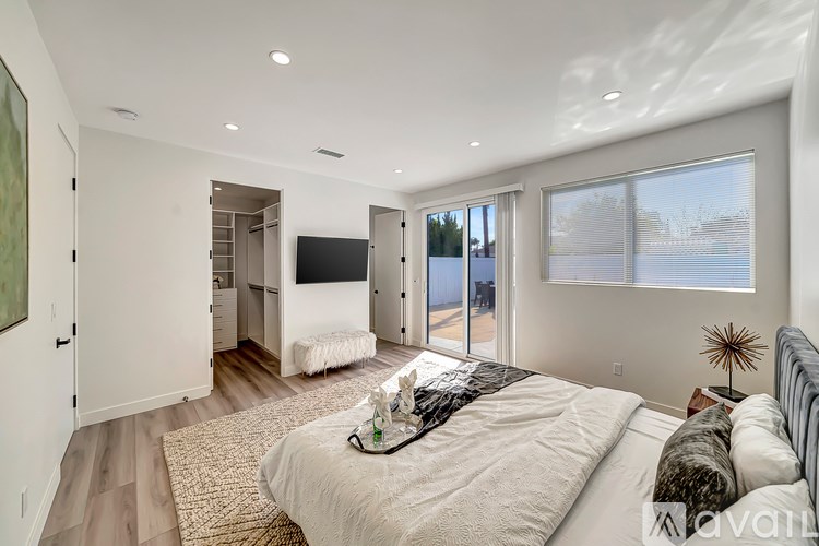 A bedroom with a large bed and a television.