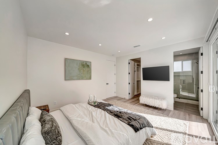 A bedroom with a large bed and a flat screen TV.