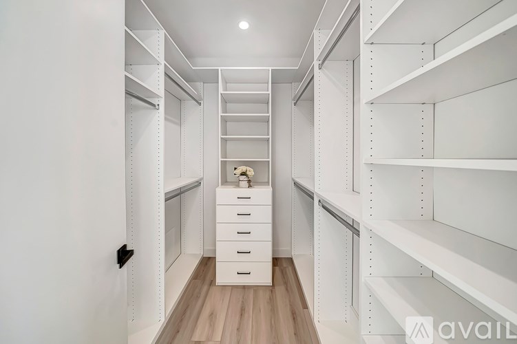 A white pantry with a staircase leading to a loft.