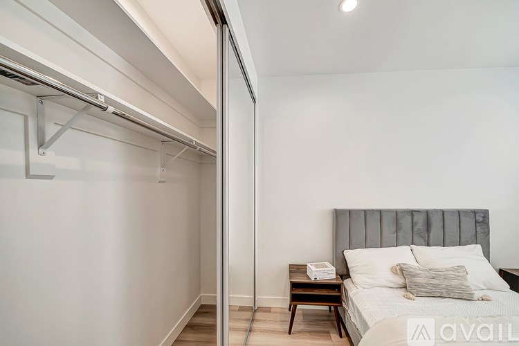 A bedroom with a bed, nightstand, and a sliding door.