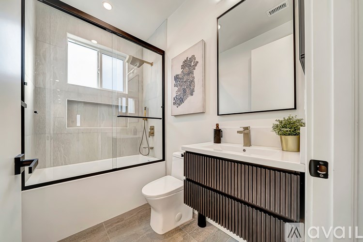 A bathroom with a toilet, sink, and mirror.