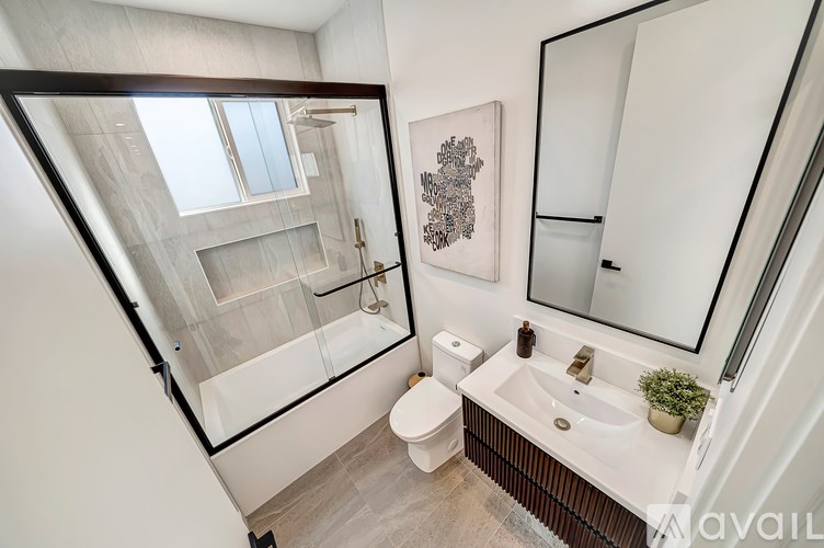 A bathroom with a toilet, sink, and mirror.