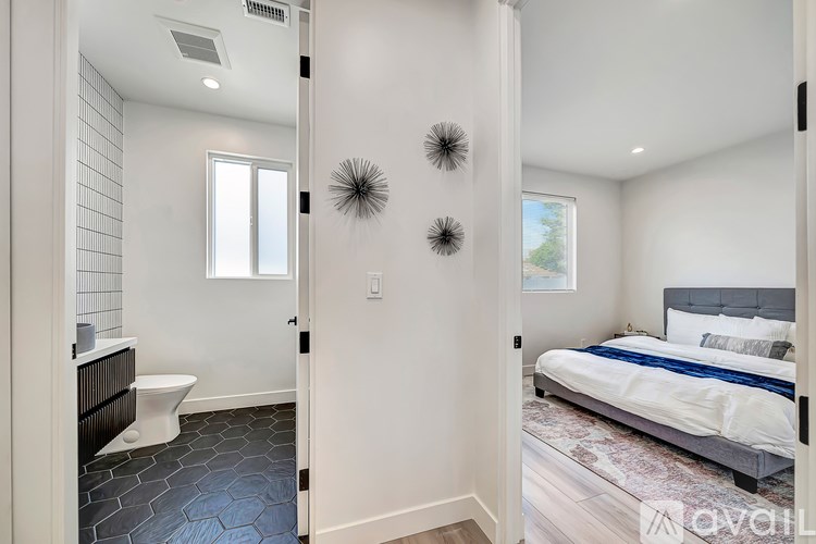 A bedroom with a bed, toilet, and a window.