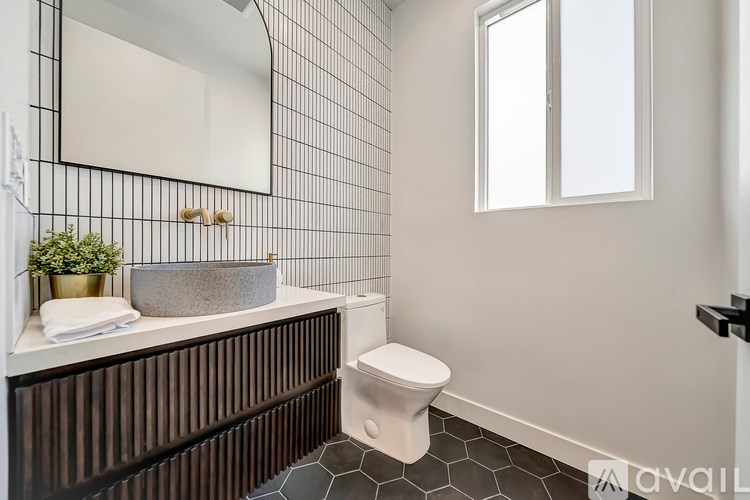 A bathroom with a toilet, sink, and mirror.