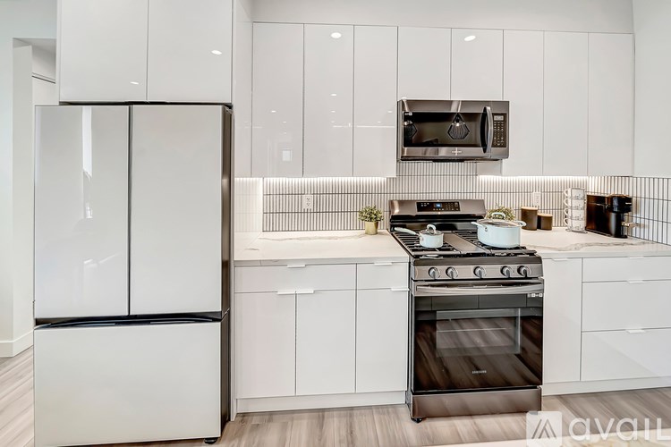 A modern kitchen with a stainless steel refrigerator and oven.