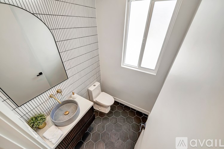 A bathroom with a toilet, sink, and mirror.