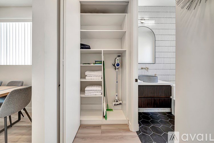 A bathroom with a white chair and a white cabinet with a mirror above it.