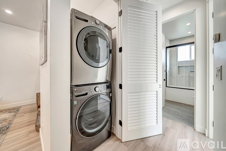 A modern washing machine is built into a wall in a clean, white room.