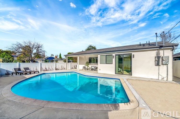 A swimming pool in a backyard with a house in the background.