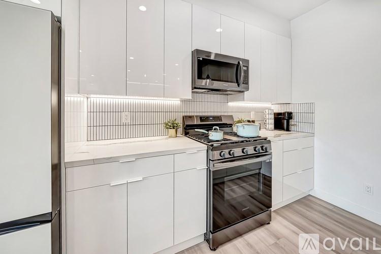 A modern kitchen with a stainless steel oven and microwave above it.