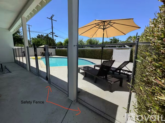 A patio with a table and chairs and a potted plant.