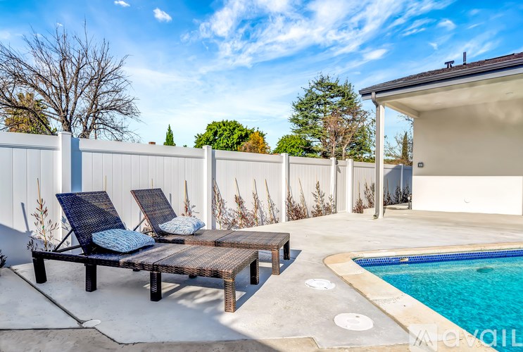 A poolside patio with a table and chairs.