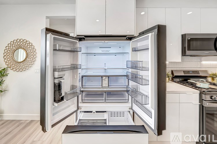 A modern kitchen with a large open refrigerator.