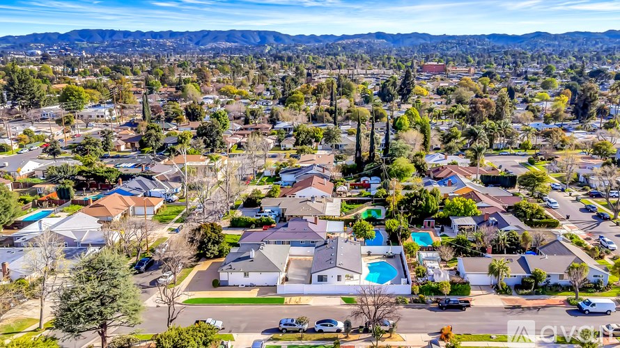 A bird's eye view of a residential neighborhood with houses and swimming pools.