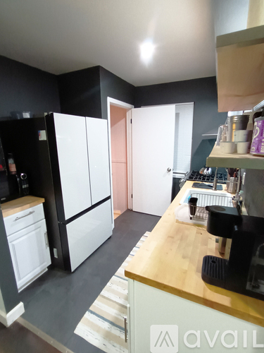 A kitchen with white cabinets and a wooden counter.