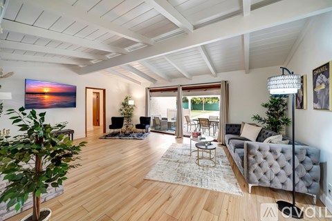A living room with a grey couch and a wooden floor.