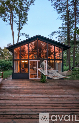 A wooden cabin with a hammock outside.