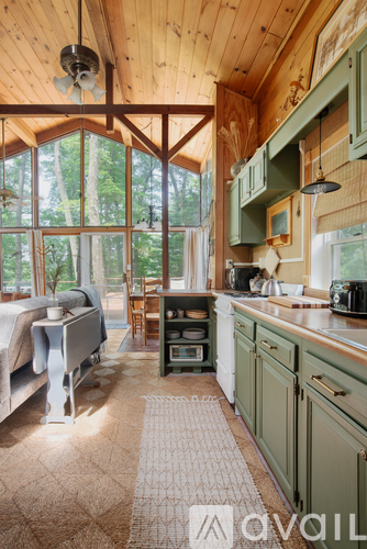 A kitchen with green cabinets and a wooden ceiling.