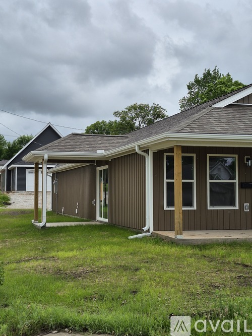 A house with a brown siding and a grey roof is shown.