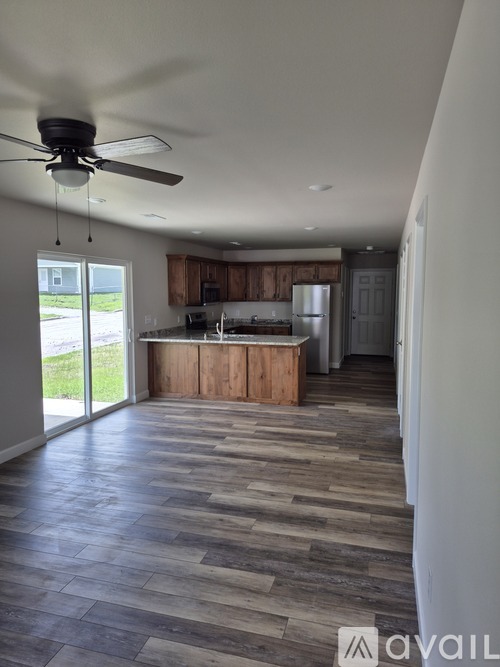 A kitchen with wooden cabinets and a ceiling fan.
