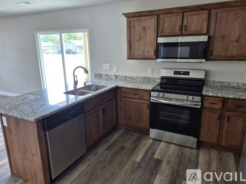 A kitchen with wooden cabinets and a granite countertop.