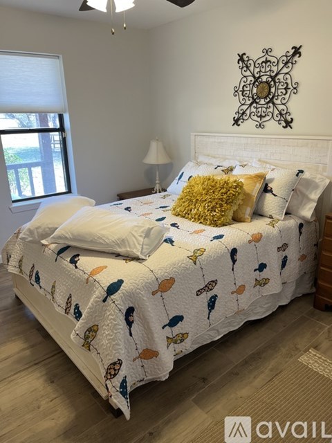 A bed with a white comforter and a yellow pillow is in the image.