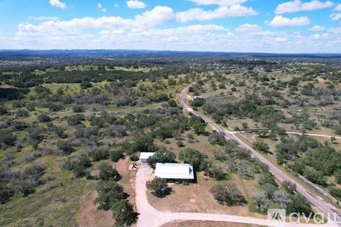 A house is surrounded by greenery in a rural area.
