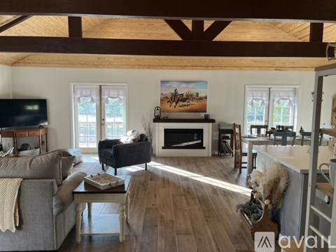 A living room with a fireplace and a painting of a horse and rider on the wall.