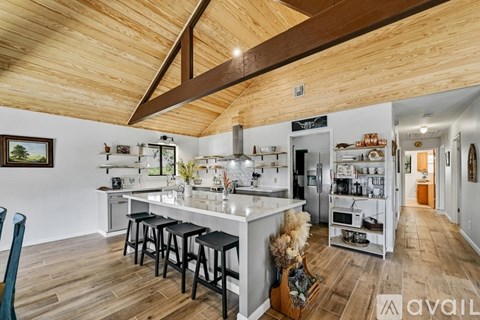 A kitchen with a wooden ceiling and a white counter.