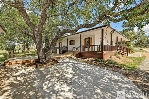 A house with a large tree in front of it.