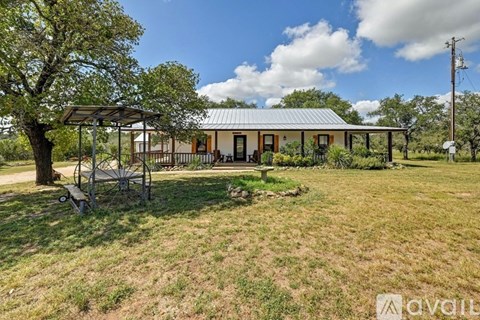 A house with a porch and a swing set in the yard.