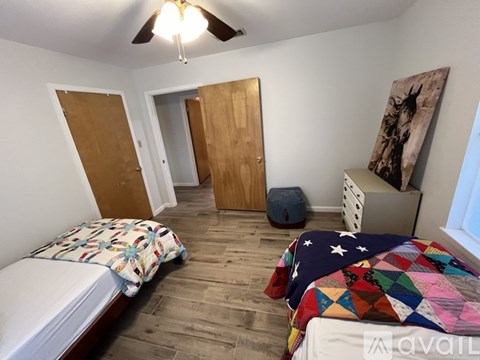 A bedroom with two beds and a ceiling fan.