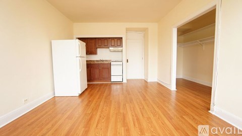 A kitchen with white appliances and wooden floors.