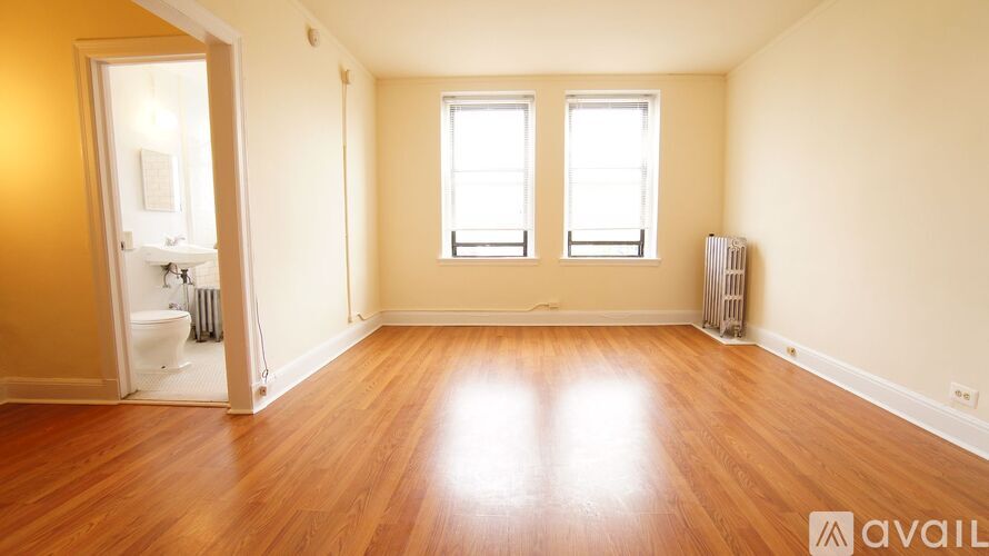 A room with wooden floors and two windows.