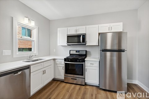 A kitchen with white cabinets and stainless steel appliances.