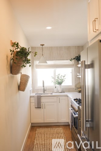 A kitchen with white cabinets and a stainless steel refrigerator.