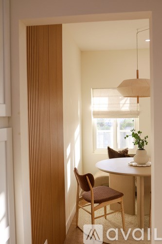 A room with a table, chair and a lamp.