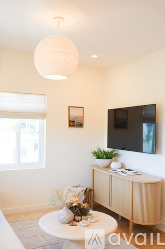 A living room with a white table and a television on the wall.